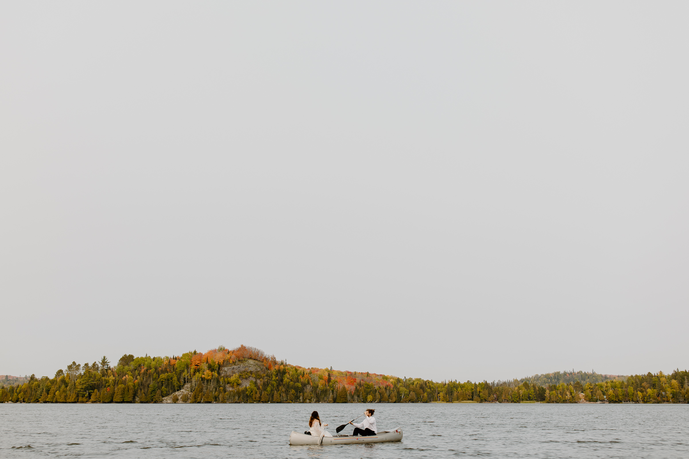 bride and groom canoeing on a little lake on the north shore of minnesota