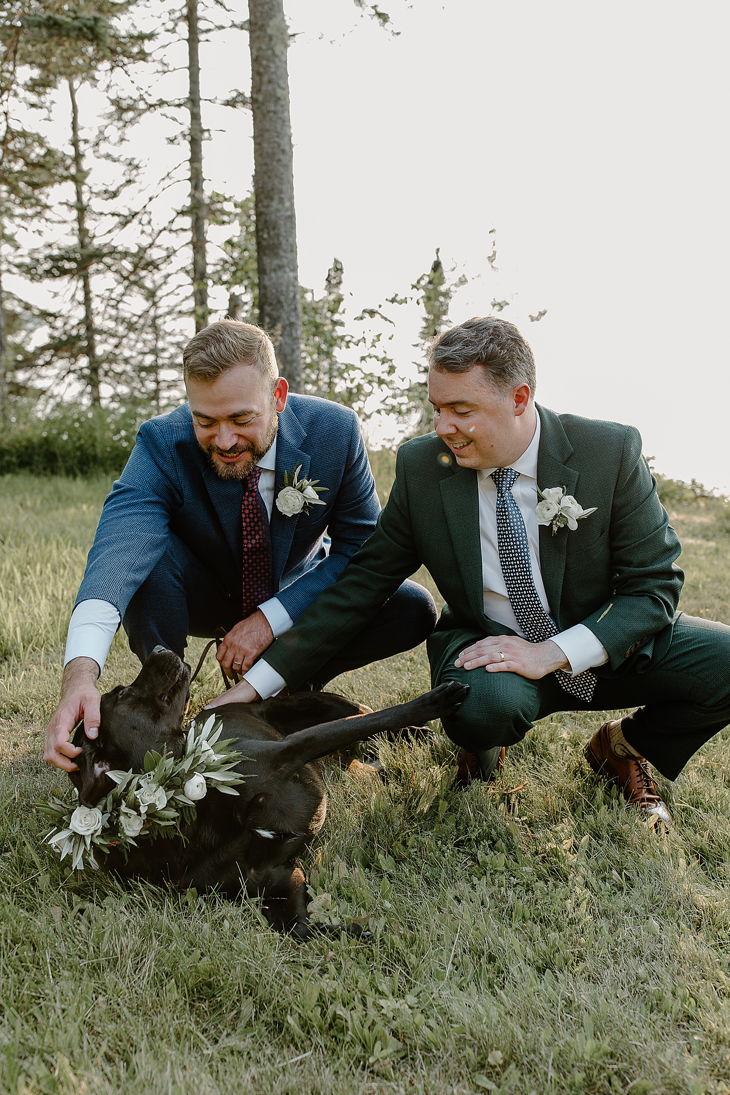 gay couple pet their dog after ceremony at Herbster WI Elopement