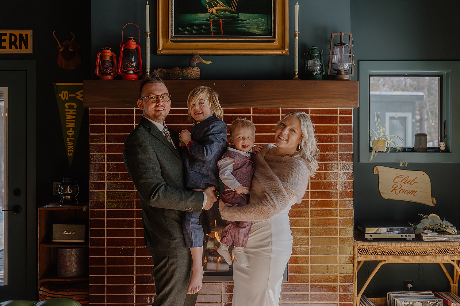 family of four in front of modern fireplace for airbnb elopement