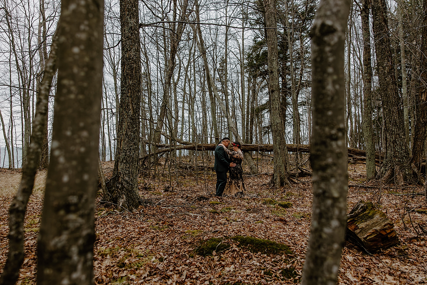 newlyweds embrace under the forest trees for Beltane Elopement