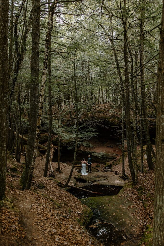 newlyweds walk hand in hand through fantasy-inspired forest by Samantha Burke Photography