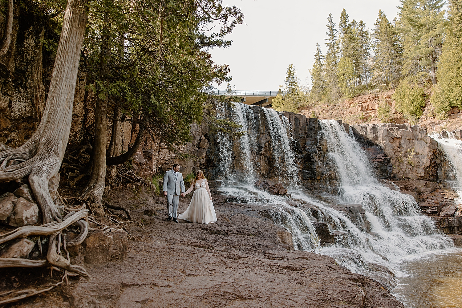 couple walks hand in hand during the best time to elope at gooseberry falls state park