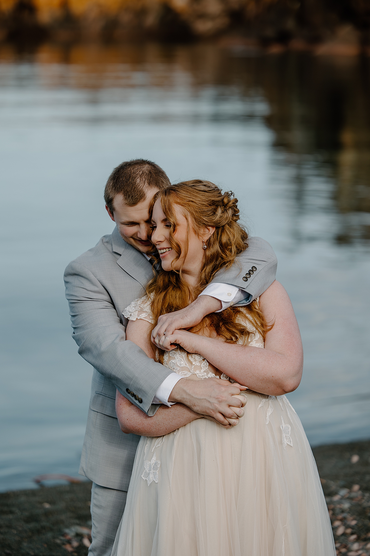 redhead bride smiles as man hugs her by Minnesota Elopement Photographer