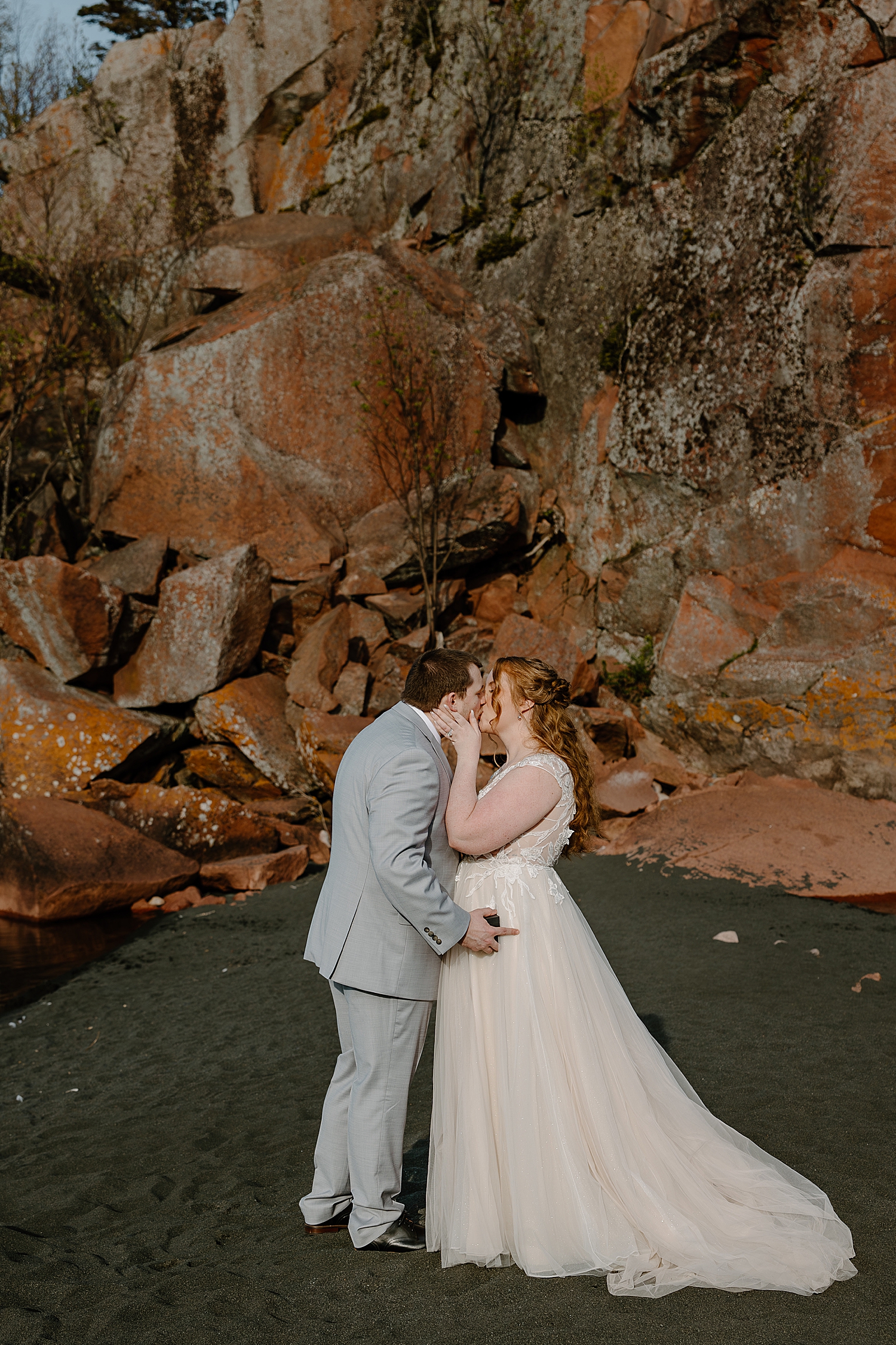 newlyweds kiss on North Shore during ceremony by Minnesota Elopement Photographer