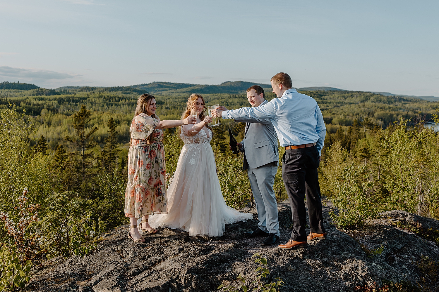 newly married couple toasts with friends on cliff by Samantha Burke Photography