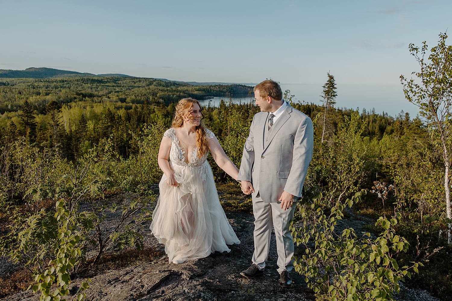 husband and wife walk on cliffside by Samantha Burke Photography
