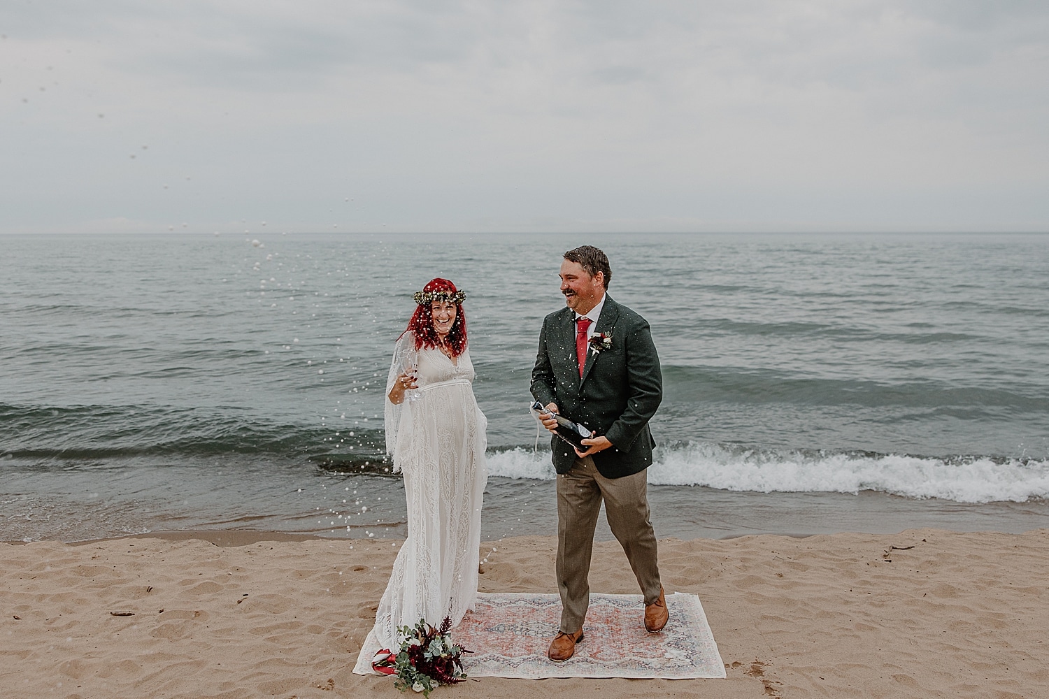 newlyweds share a glass of champagne near great lake by Minnesota wedding photographer