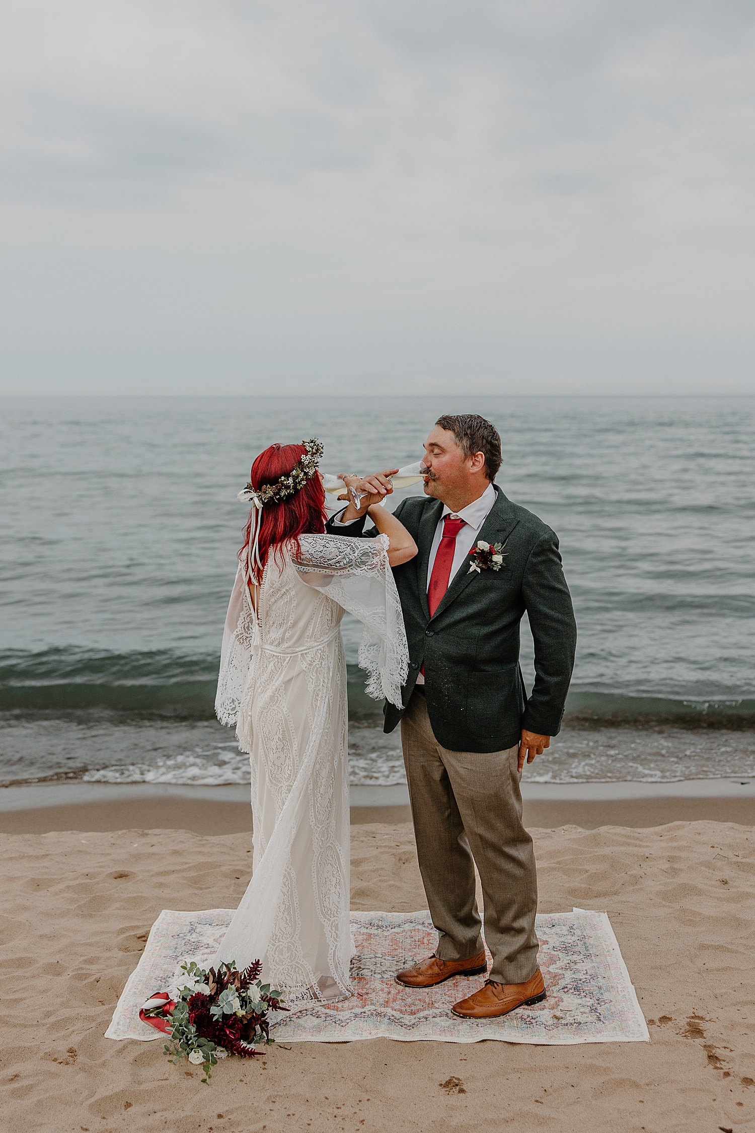woman with red hair and man in suit intertwine arms for drink of champagne by Samantha Burke Photography