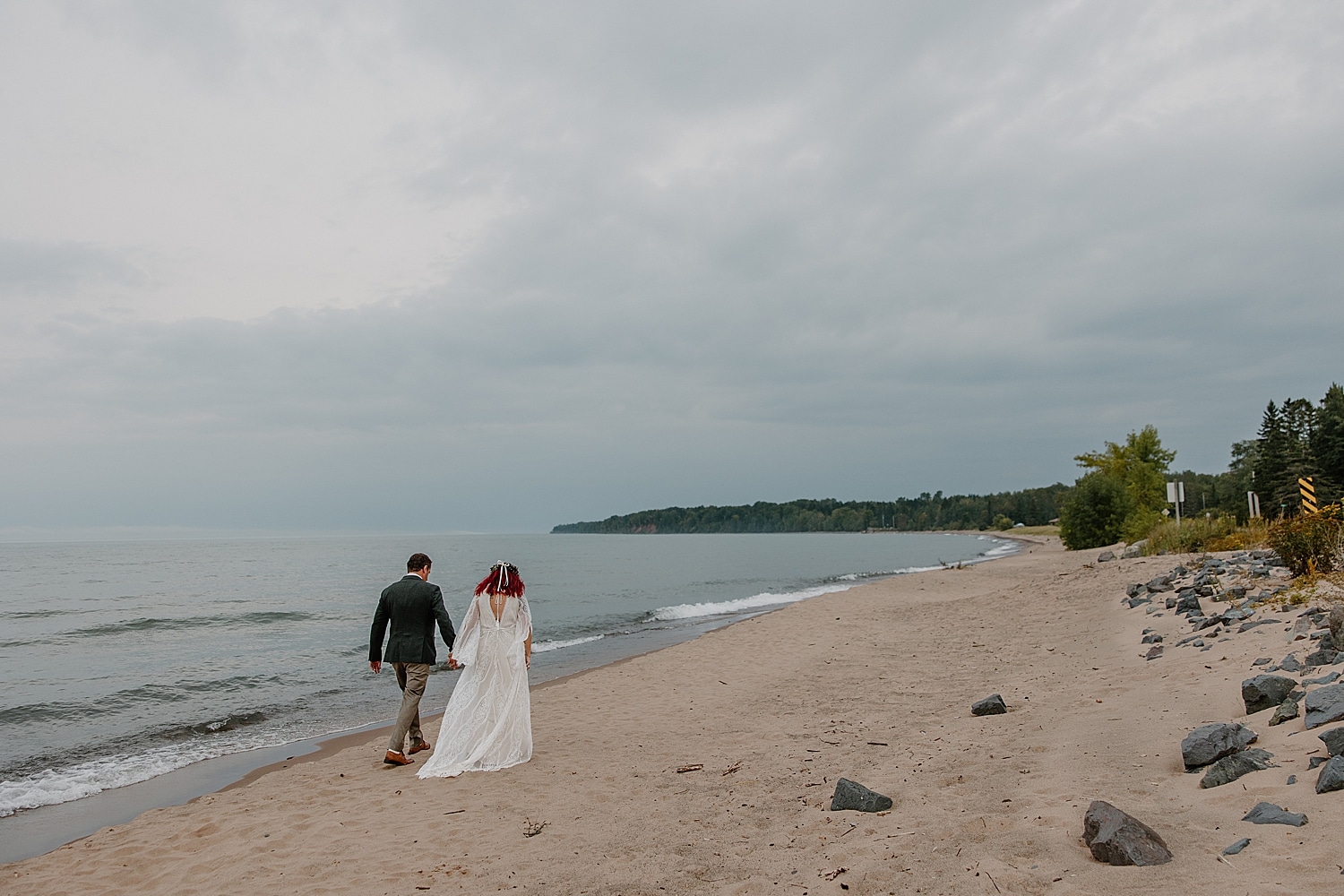 newly married couple walks along the shoreline for Wisconsin Beach Elopement