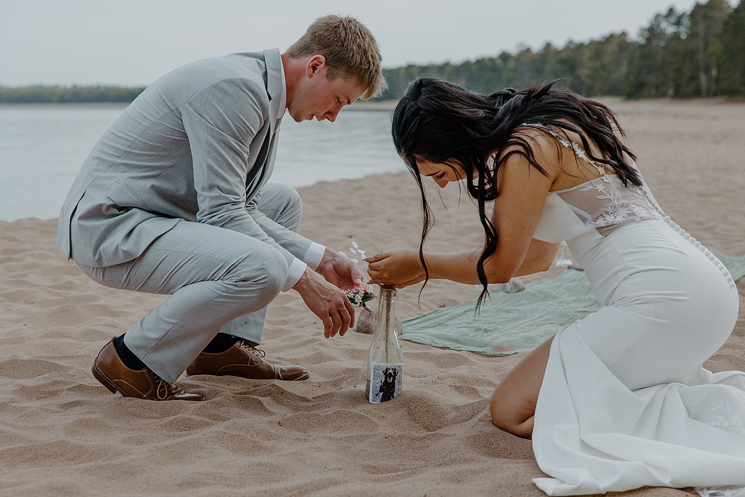 newlyweds pour sand into custom wine bottle showing how to include pets in your elopement