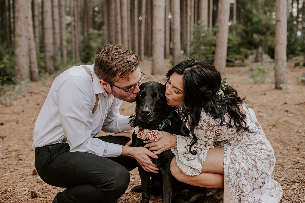 bride and groom kiss mutt with a floral chain by Wisconsin wedding photographer