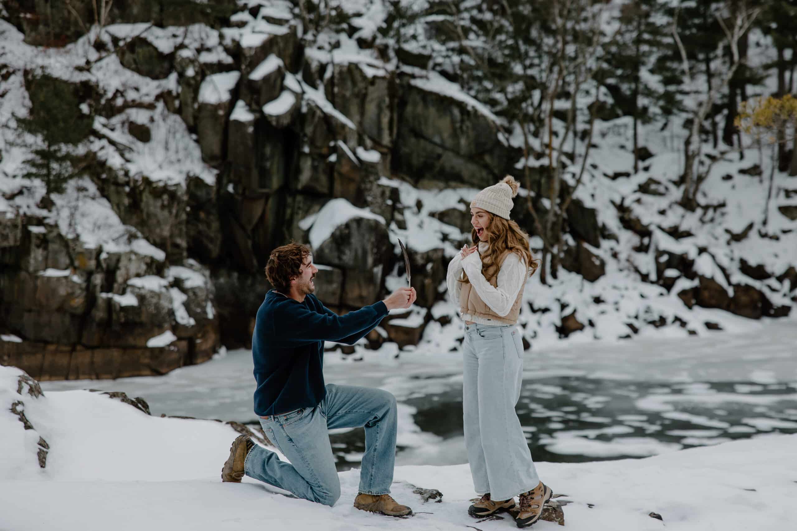 man holds up ring to blonde by Wisconsin wedding photographer