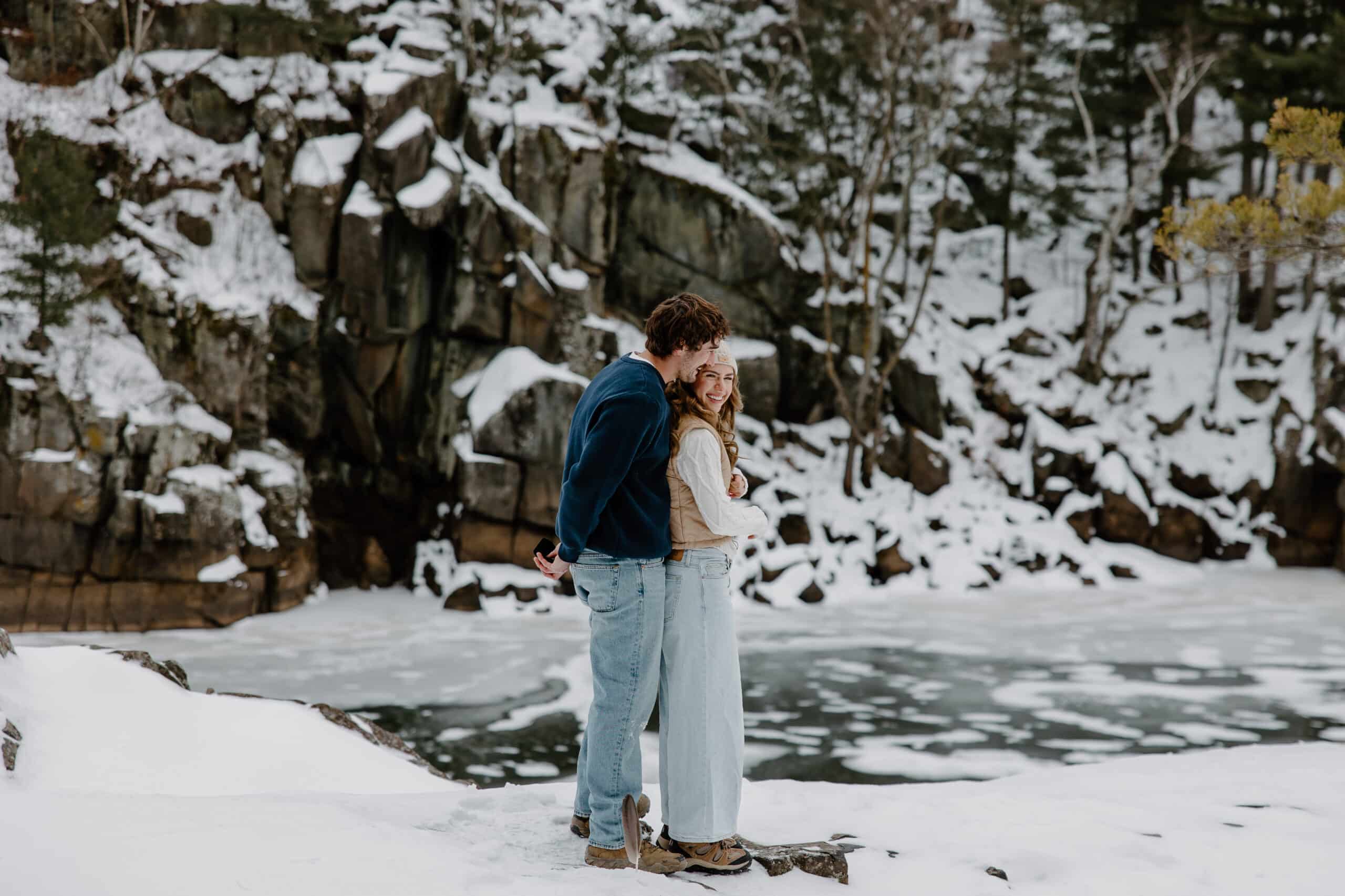 man snuggles up behind woman in the snow for Interstate State Park Winter Proposal