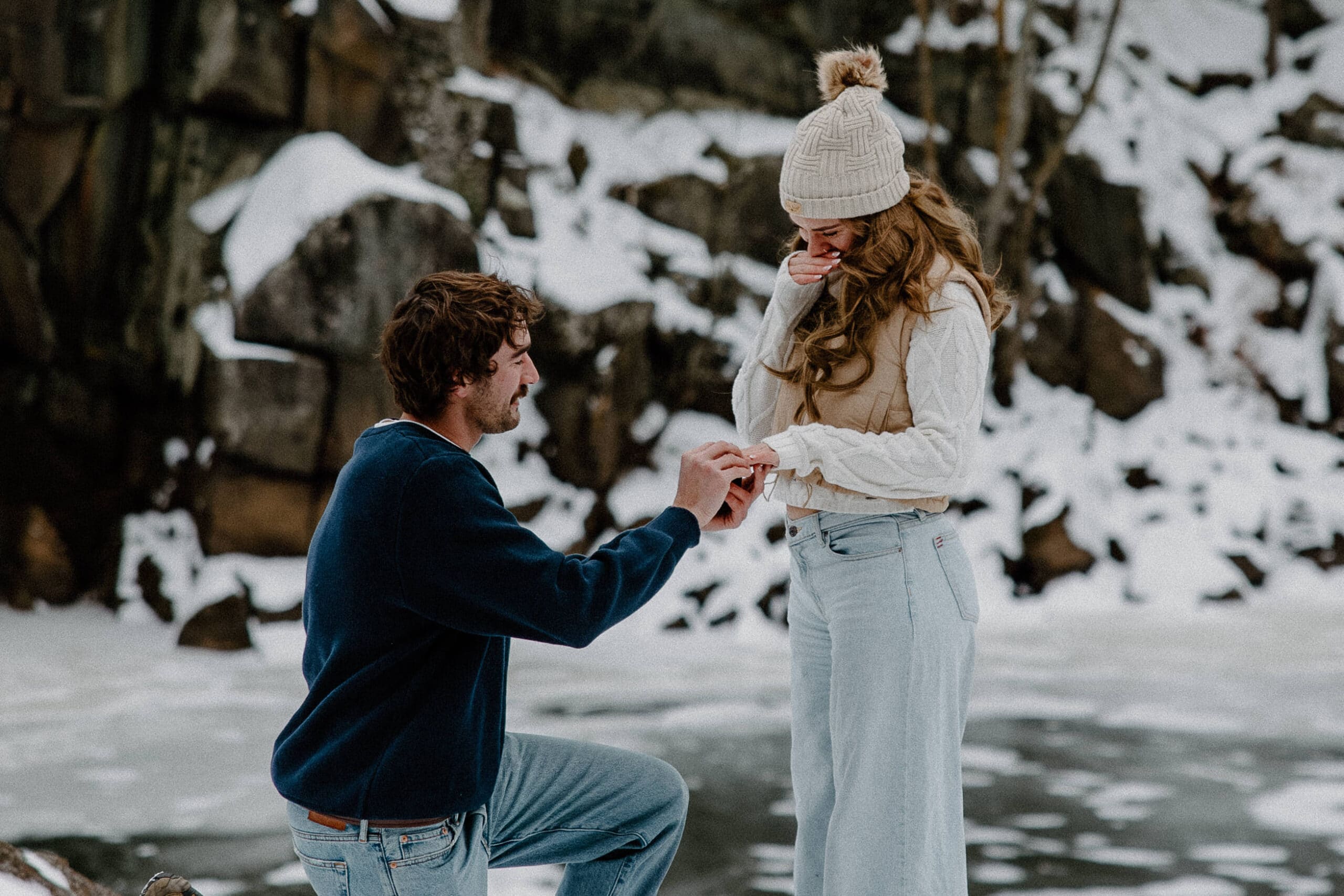groom kneels in the snow to ask bride a question for Interstate State Park Winter Proposal