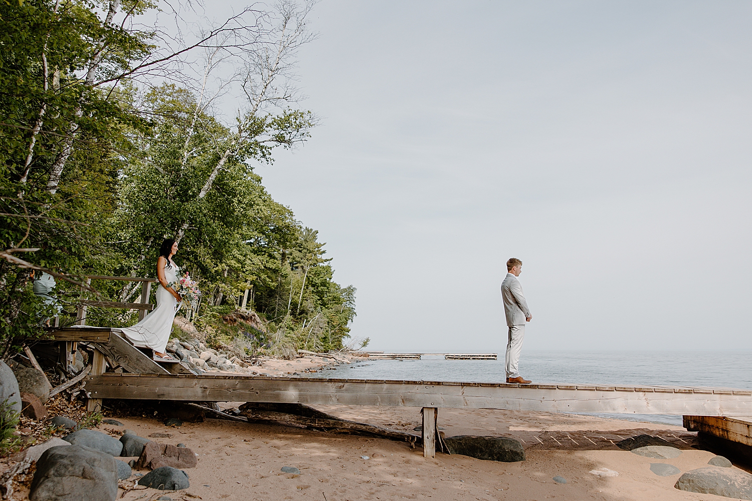 woman approaches man on dock for first look by Samantha Burke Photography