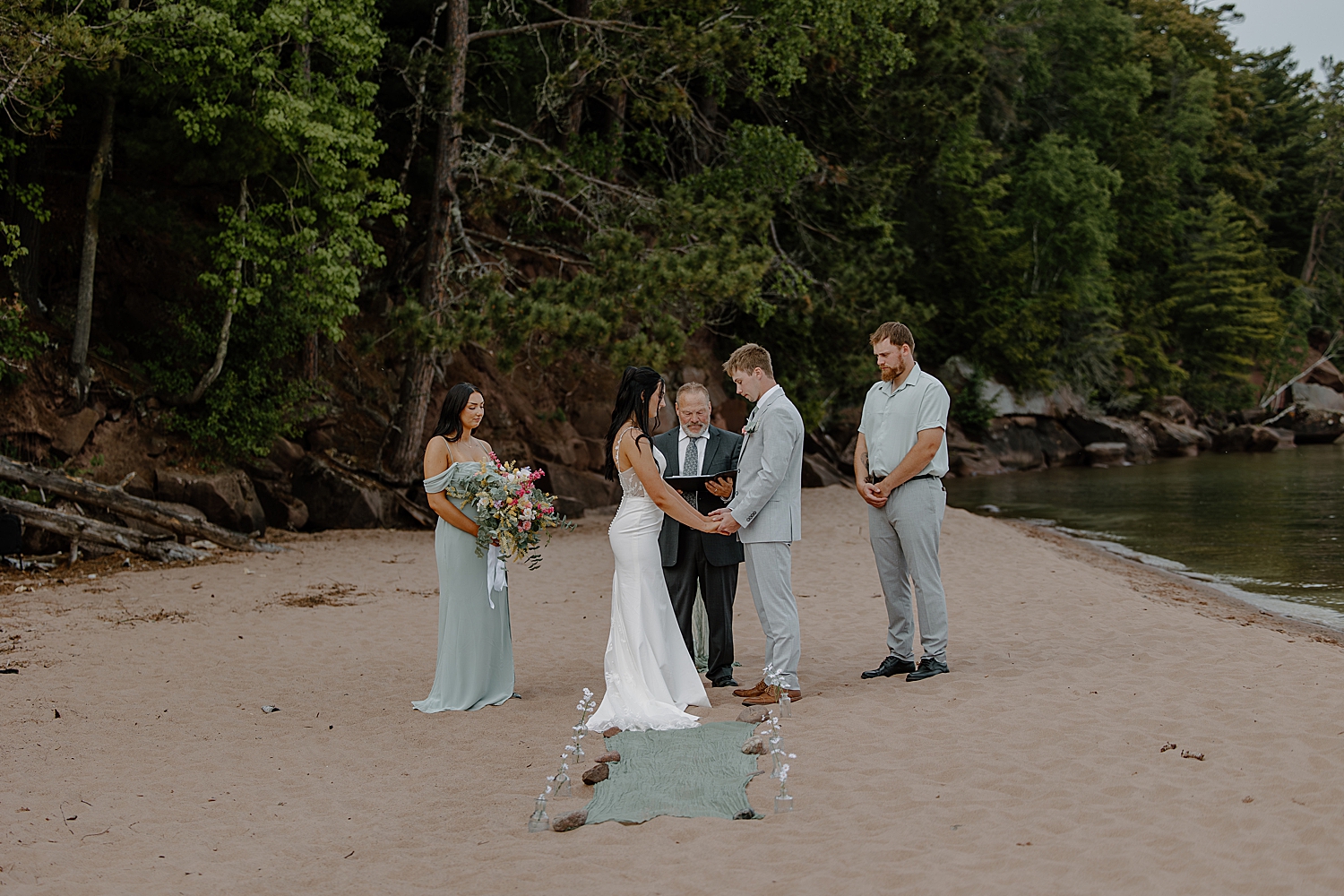 couple and their friends stand for ceremony on beach by Samantha Burke Photography