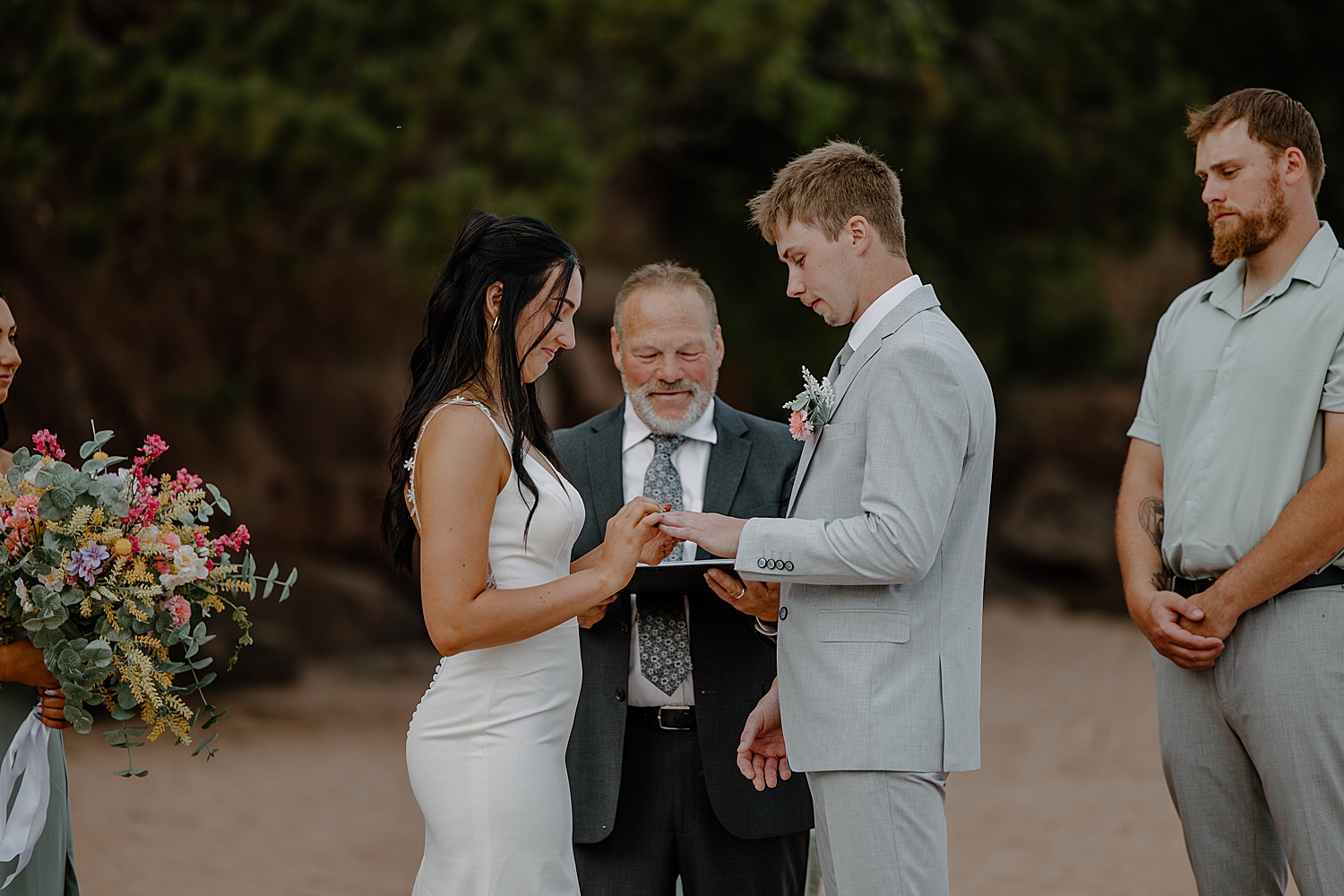 bride puts a ring on man's finger by Minnesota elopement photographer
