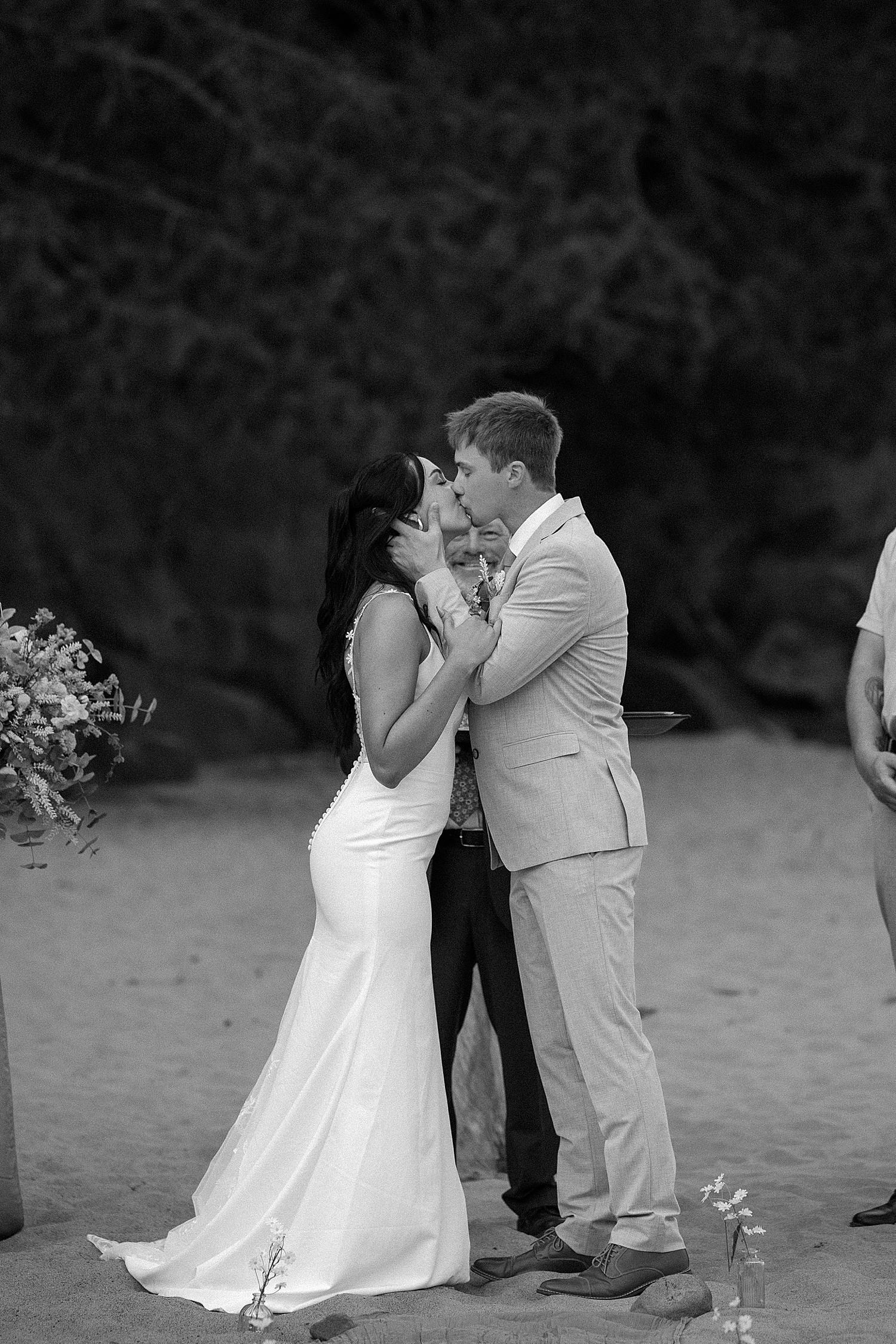 newlyweds share first kiss on beach for Lake Superior intimate wedding