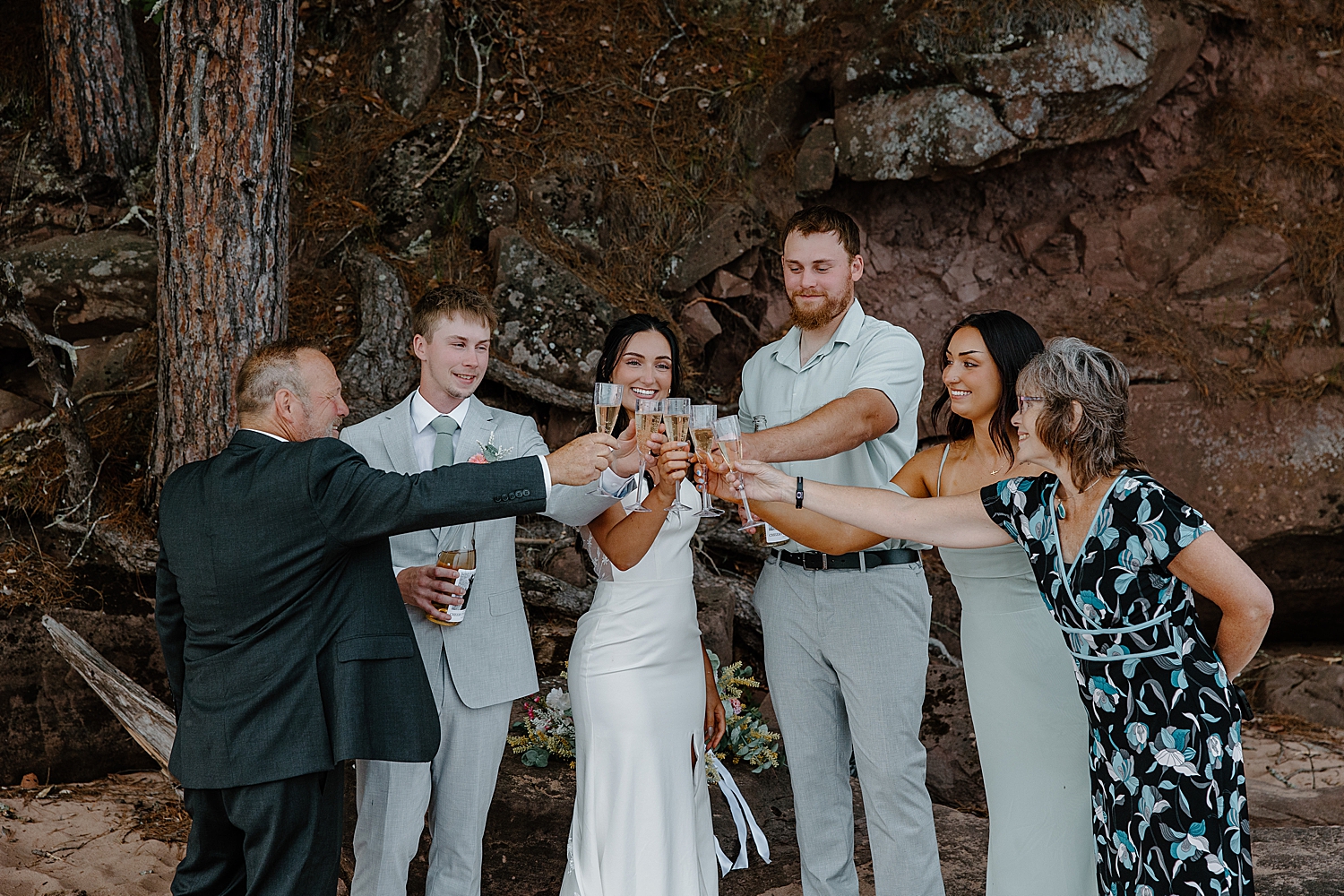 friends toast a new couple on the sand by Minnesota  elopement  photographer