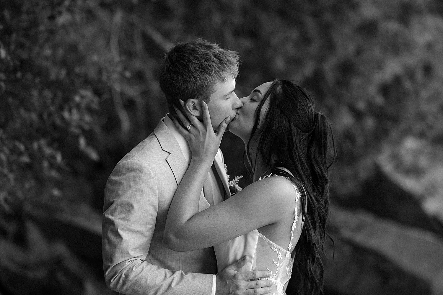 newlyweds share a kiss in front of trees for Lake Superior intimate wedding