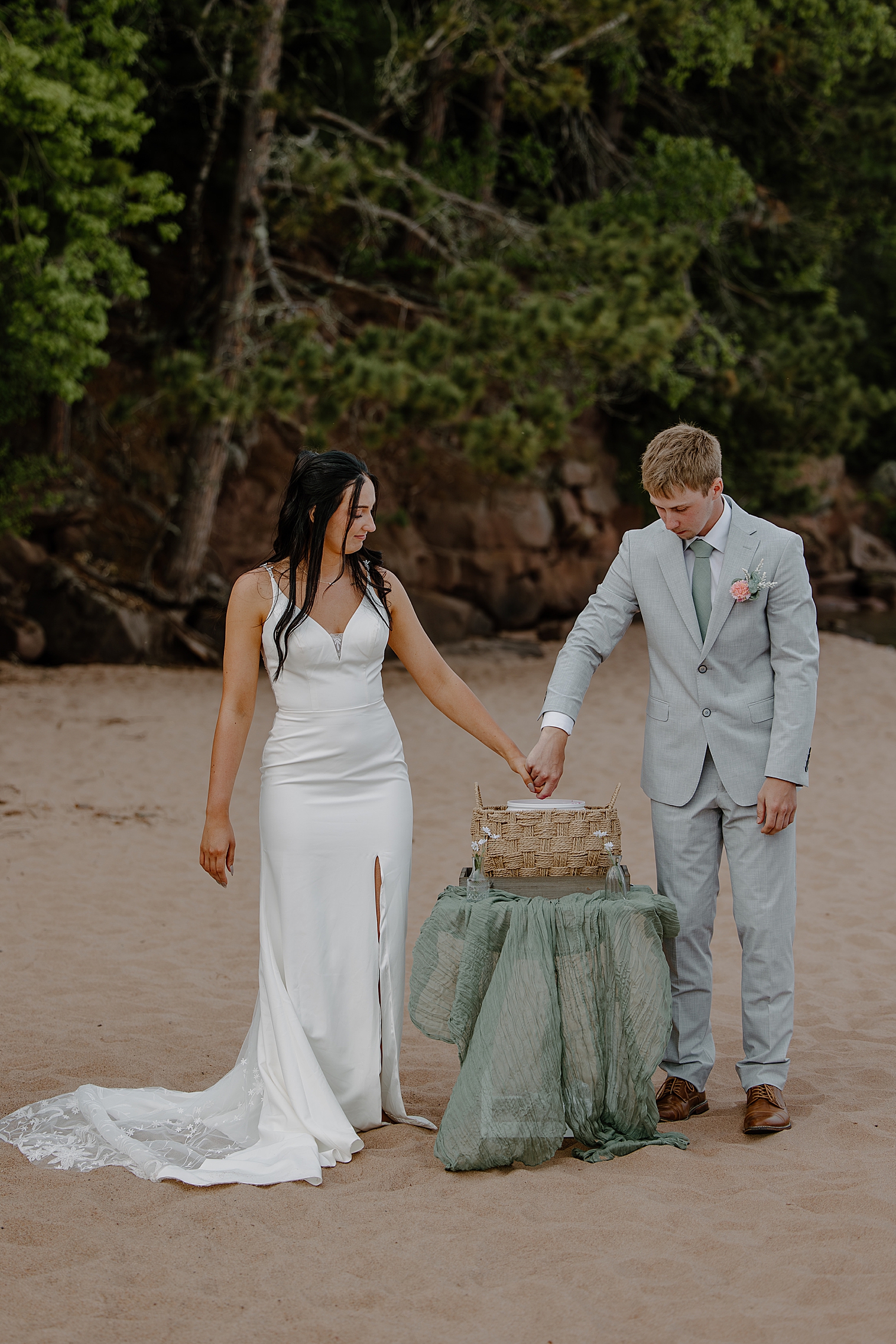two people do a hand mold on the beach by Samantha Burke Photography