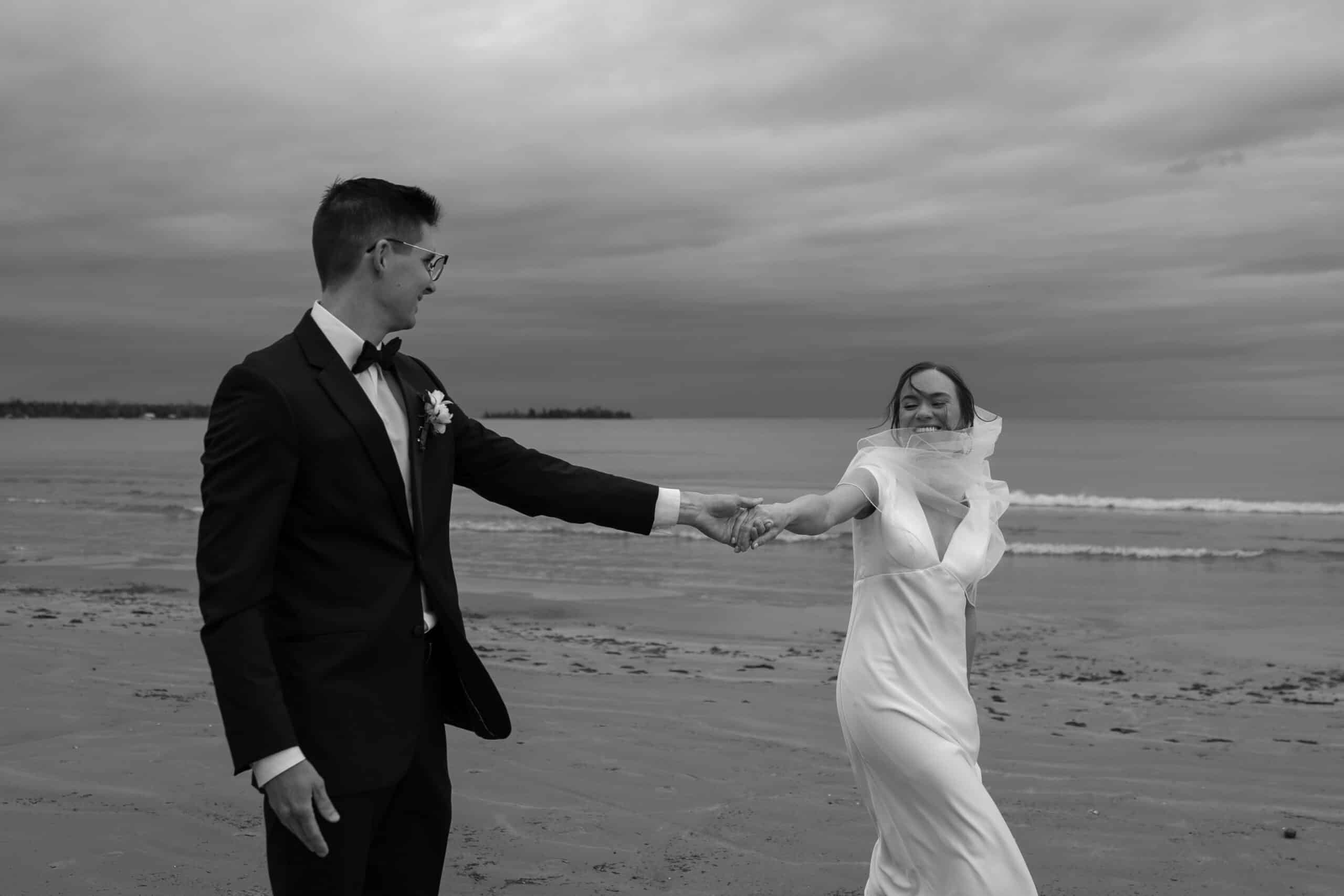 Door County WI Elopement with bride and groom walking along a beach in the wind at Bailey's Harbor