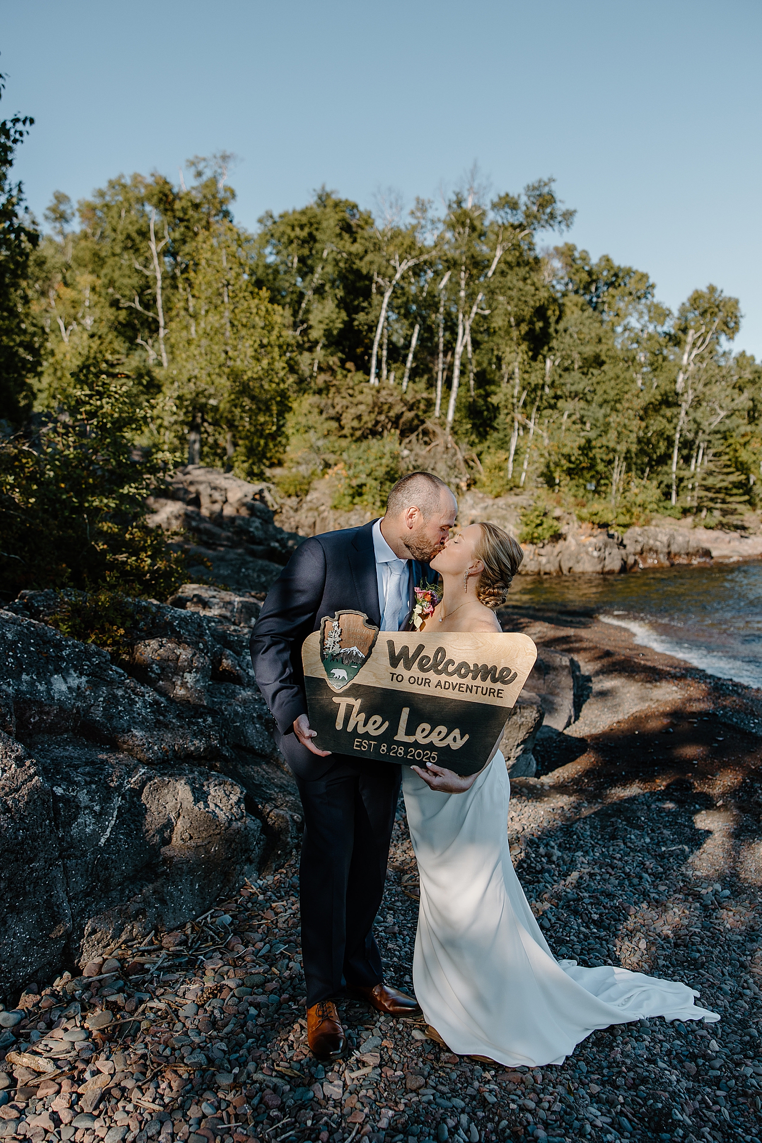couple shares a kiss holding up custom sign by Samantha Burke Photography